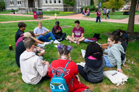 Students sit in a circle on the grass of Lafayette College's Quad.
