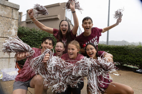 Students wave maroon and white pom poms.
