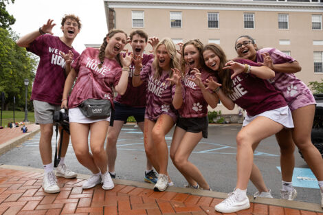 Students in matching Welcome Home t-shirts make leopard claws with their hands.