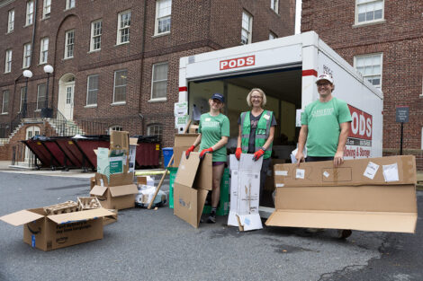 Staff help gather cardboard during Green move-in