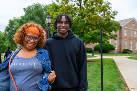 A student and their family member (who is wearing a Lafayette Mom t-shirt) smile
