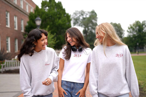 Three students smile in Bicentennial Abercrombie & Fitch clothing.