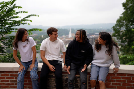 Four students sit at the Easton overlook, wearing Bicentennial Abercrombie and Fitch clothing