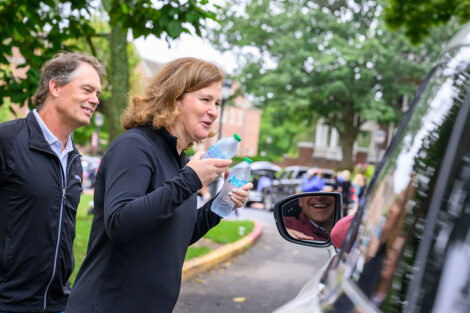 President Nicole Hurd and Bill Hurd give water bottles to families arriving during Move-In weekend.