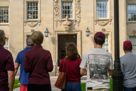 A group of visitors are standing in front of Kirby Hall during the architectural tour.