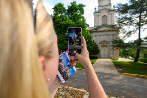 A woman takes a cell phone photo of Colton Chapel.