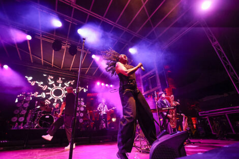 Fitz and the Tantrums perform on stage, surrounded in blue and purple lights.