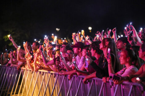 The crowd enjoys the music with their cellphones up.