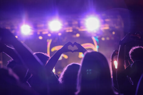 A student holds up the heart symbol with their hands.