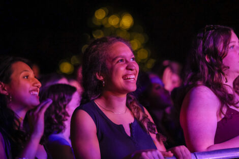 A student smiles from the crowd.
