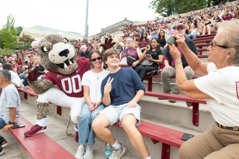 The Leopard mascot smiles with families.
