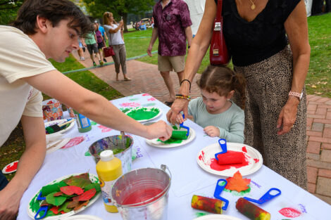 A child paints leaves.