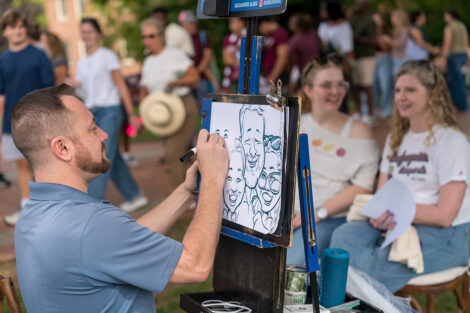 A person makes a caricature of three people.