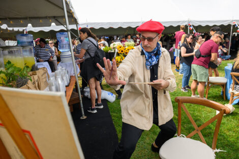 An artist holds their paint brush in front of them.