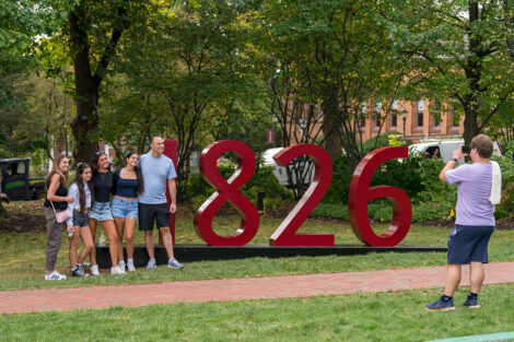 Families smile outside of a giant 1826 sign.