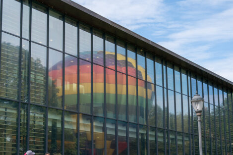 The hot air balloon reflects off of Skillman Library's windows.
