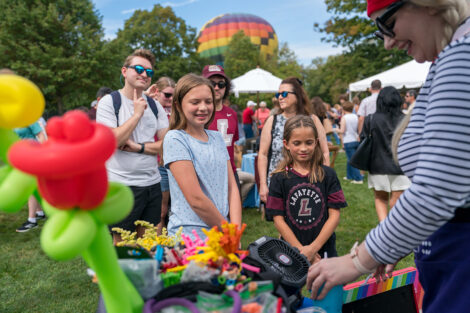 Two children wait in line for a balloon animal.