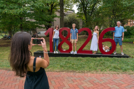 Families pose with a giant 1826 sign.