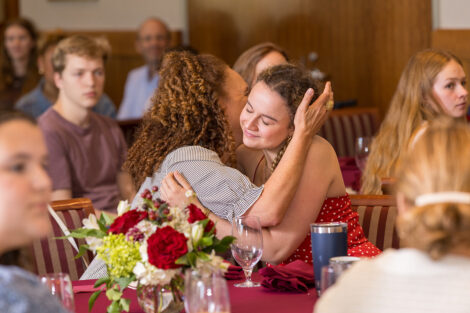 Two people embrace while seated at the Legacy Brunch.