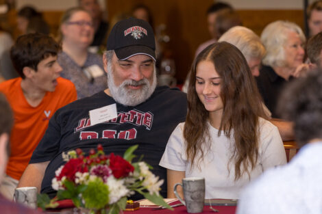 A Lafayette dad sits at a table with a student at the Legacy Brunch.