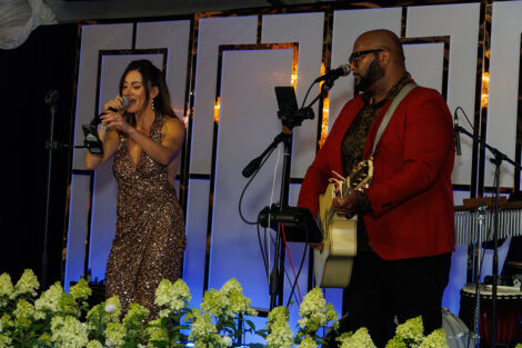 A singer and guitarist perform on stage at the dinner.