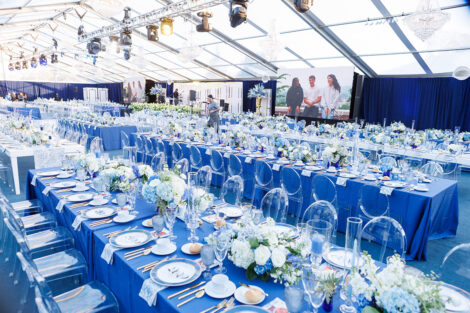 French themed table settings and furniture were the theme for the Marquis Founders Dinner. A large screen is seen in the background.