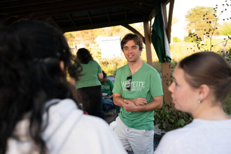 A person wearing a Lafayette Sustainability shirt speaks to attendees at Lafarm.