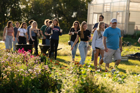 Community members walk near flowers during a tour of LaFarm
