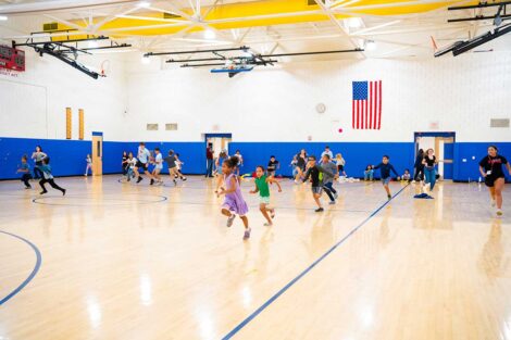 Lafayette POSP students running with Paxinosa Elementary School students in a gym