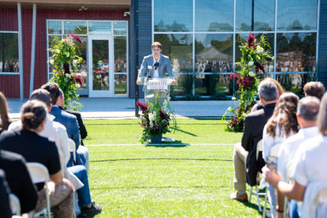 Men's lacrosse player Andrew Matarese '28 addresses a crowd from a podium.