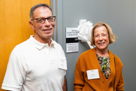 Bob Bazarian '76 and Debra Keeler stand near a named space inside the Wallach Center.