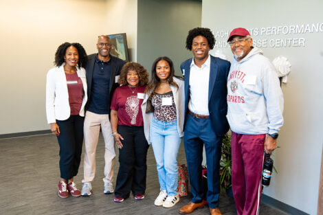 Men's lacrosse player Jared Baudin ‘29 (second from right) with five members of his family stand in the lobby of the Wallach Center.
