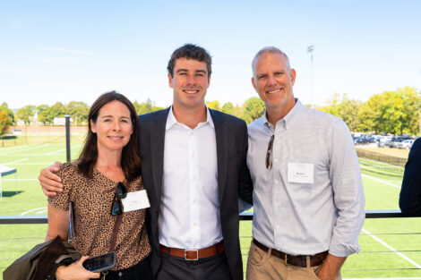 Men's lacrosse player Andrew Pfeiffer '28 is pictured with his parents at the rooftop viewing area.