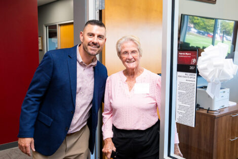 Coach Myers and Peggy Lawson stand outside Myers' office in the Wallach Center.