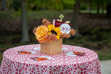 Flowers on the center of a table, decorated with Lafayette College logos.