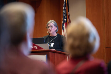 Elaine Stomber speaks at a podium.