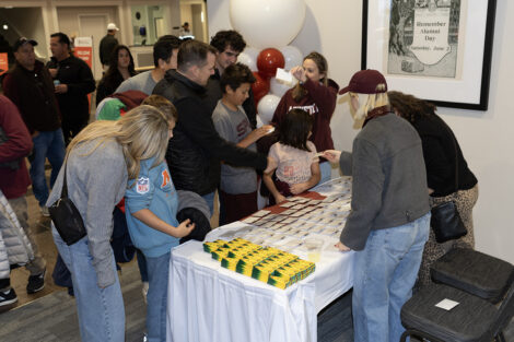 Alumni check in at a white table, getting ready for the event.