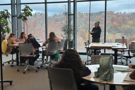 Girl Scouts sitting at tables in a Lafayette classroom during a badge session on Girl Scout Badge Day