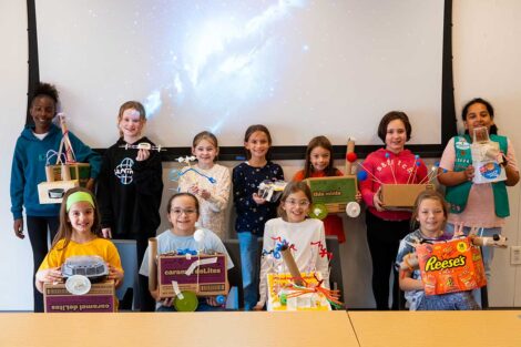 Girl Scouts pose with their finished science projects for Girl Scout Badge Day