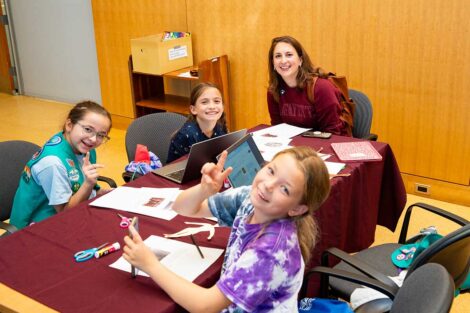 Girl Scouts posing with Lafayette staff during Girl Scout Badge Day