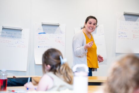 Sofia Serrano stands in front of a whiteboard teaching a session to scouts.