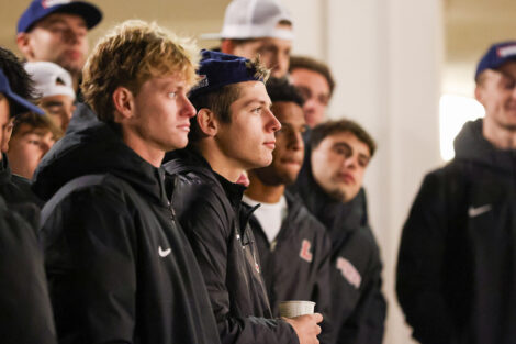 Men's soccer team members watch the lighting of the Quad.