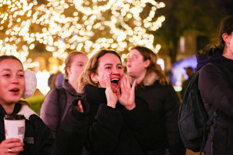 A student enjoys the lights on the Quad.