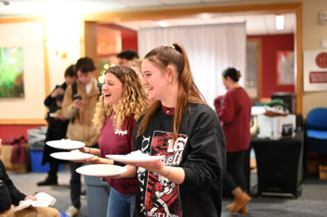 Students hold whip cream pies.