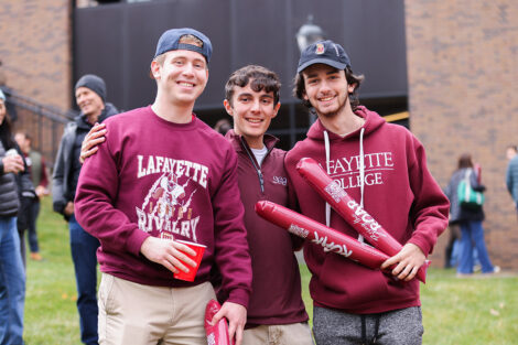 Lafayette College community members smile, dressed head to toe in leopard and maroon gear.