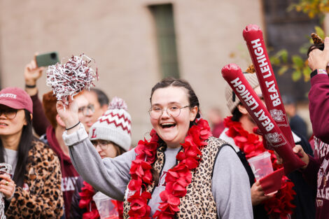 Lafayette College community members cheer, dressed head to toe in leopard and maroon gear.