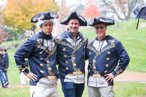 Alumni wear colonial clothes and hats that read