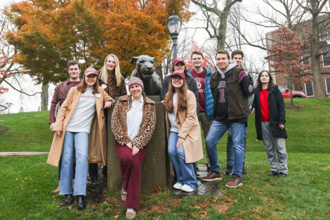 Alumni decked out in Lafayette and leopard gear stand around the Leopard statue.