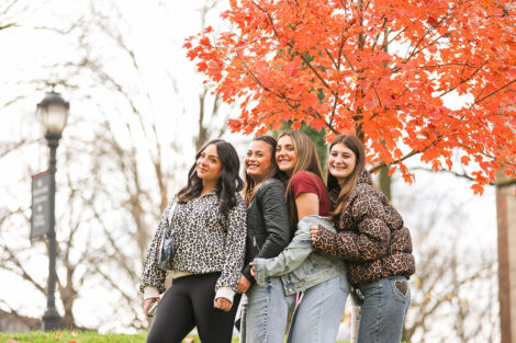 Lafayette College community members smile, dressed head to toe in leopard and maroon gear.