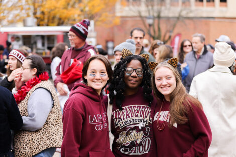 Lafayette College community members smile, dressed head to toe in leopard and maroon gear.